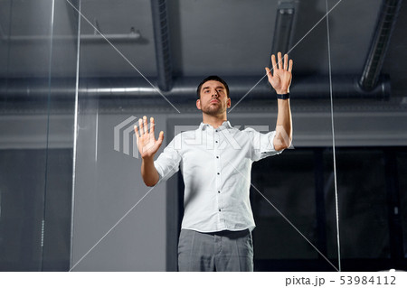 businessman touching glass wall at night office businessman touching glass wall at night office 53984112