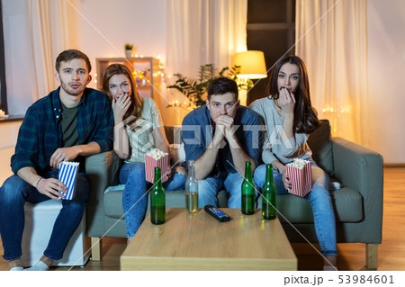 friends with beer and popcorn watching tv at home friends with beer and popcorn watching tv at home 53984601