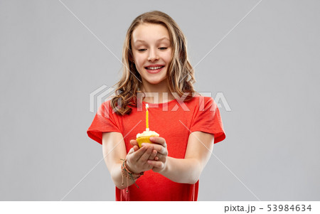 teenage girl with one candle on birthday cupcake teenage girl with one candle on birthday cupcake 53984634