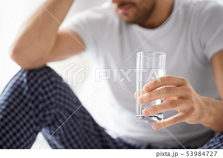 close up of sick man with glass of water close up of sick man with glass of water 53984727