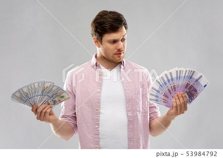 uncertainy man with fans of euro and dollar money 53984792