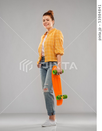 red haired teenage girl with short skateboard 53984841