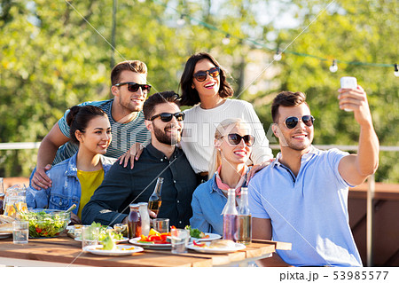happy friends taking selfie at rooftop party 53985577