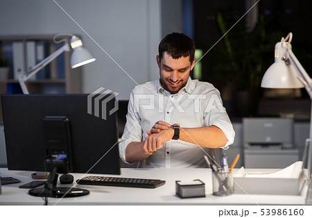 happy businessman with smart watch at nigh office happy businessman with smart watch at nigh office 53986160