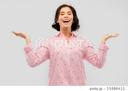 happy young woman in pajama shrugging 53986413