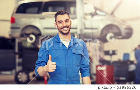 happy auto mechanic man or smith at car workshop 53986526