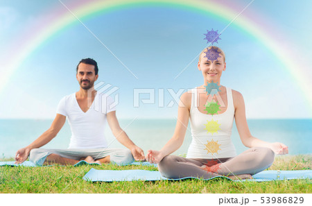 couple doing yoga in lotus pose with seven chakras couple doing yoga in lotus pose with seven chakras 53986829