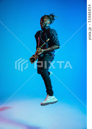 Young african-american jazz musician playing the saxophone Young african-american jazz musician playing the saxophone 53986854