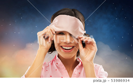 happy young woman peeking from under sleeping mask happy young woman peeking from under sleeping mask 53986934