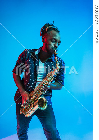 Young african-american jazz musician playing the saxophone Young african-american jazz musician playing the saxophone 53987387