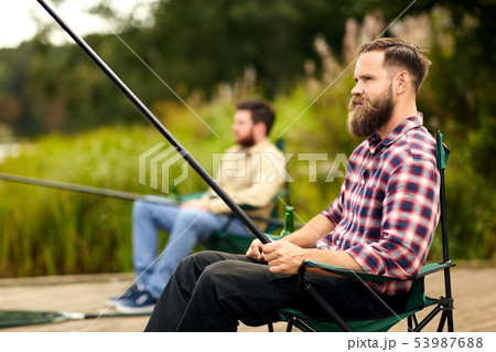 bearded man with friend fishing at lake bearded man with friend fishing at lake 53987688