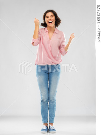 young woman in shirt and jeans celebrating success young woman in shirt and jeans celebrating success 53987779