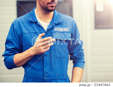 close up of auto mechanic smoking cigarette close up of auto mechanic smoking cigarette 53987864