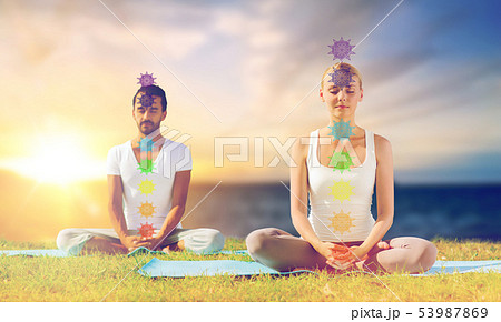 couple doing yoga in lotus pose with seven chakras 53987869
