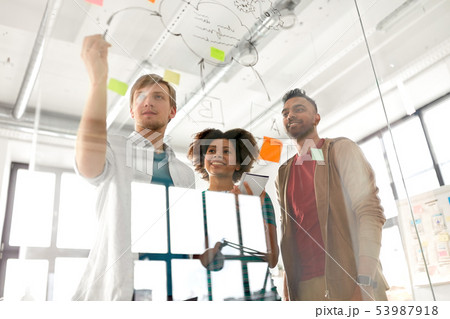 happy creative team at office glass board 53987918