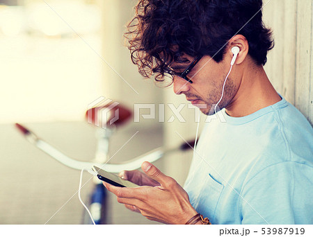 man with smartphon, earphones and bicycle 53987919
