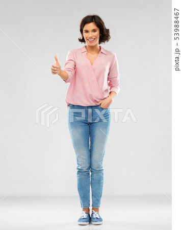 young woman in shirt and jeans showing thumbs up young woman in shirt and jeans showing thumbs up 53988467