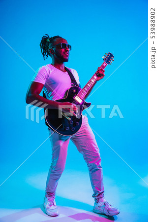Young african-american jazz musician playing the guitar Young african-american jazz musician playing the guitar 53988902
