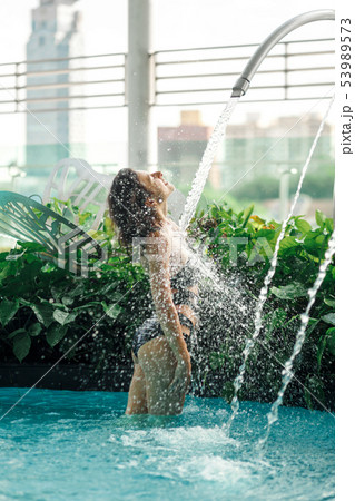 Sexy slim female in swimsuit takes shower in 53989573