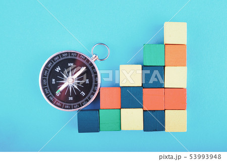 compass and colorful cube on blue background compass and colorful cube on blue background 53993948