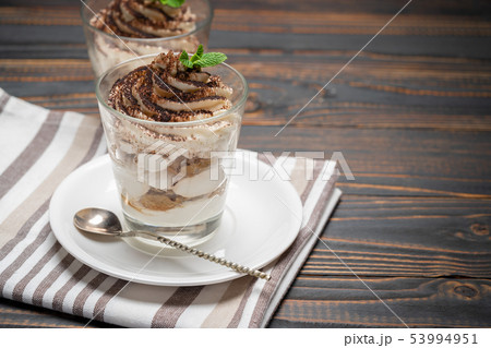 Classic tiramisu dessert in a glass on wooden background Classic tiramisu dessert in a glass on wooden background 53994951
