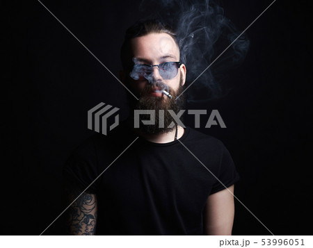 handsome smoking man. Hipster tattoed boy with 53996051