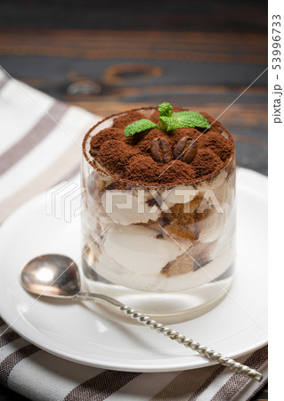 Classic tiramisu dessert in a glass on wooden background Classic tiramisu dessert in a glass on wooden background 53996733