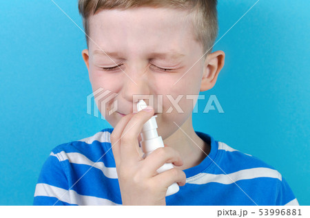 little boy with nasal spray, blue background 53996881