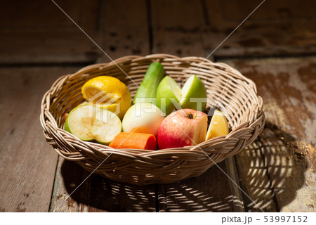 mixed fruit in wood basket on wood table in mornin 53997152