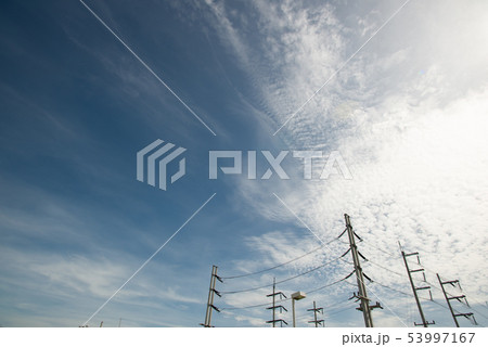 High voltage field with cloudy blue sky 53997167