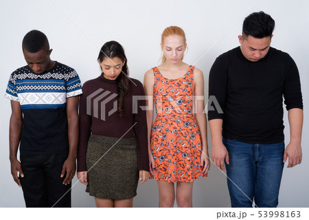 Studio shot of diverse group of multi ethnic friends looking dow 53998163