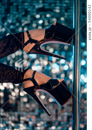Heels of sexy woman pole dancing or striptease with pylon in night club. Heels of sexy woman pole dancing or striptease with pylon in night club. 54000142