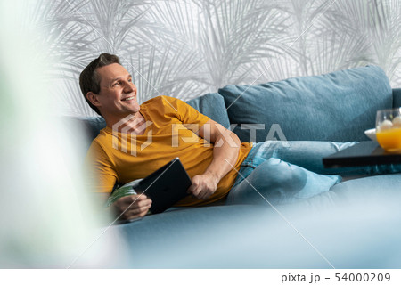 Smiling adult male having rest at home 54000209