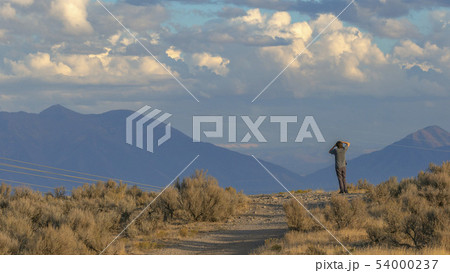 Man on a road overlooking Utah Valley on sunny day 54000237