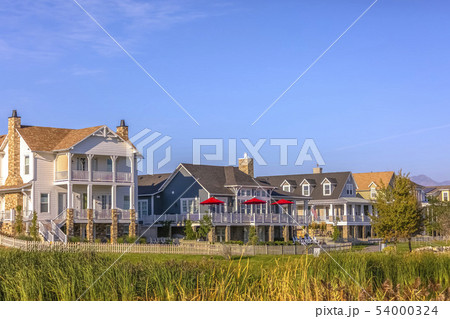 Homes with porch balcony and lawn under blue sky 54000324