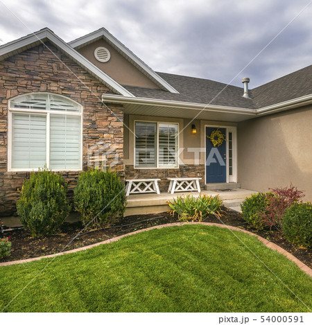 Home with yard porch and blue door against sky Home with yard porch and blue door against sky 54000591