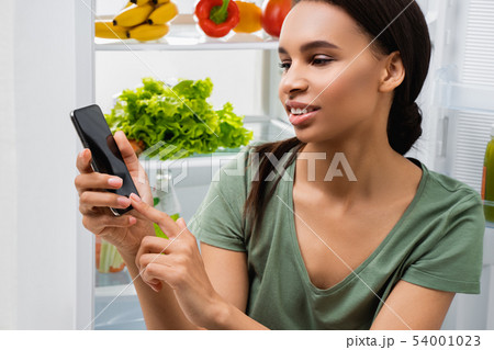 Smiling lady looking on mobile phone in hand 54001023