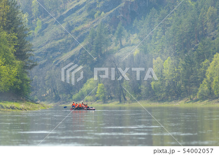 People sailing on the inflatable boat using paddles People sailing on the inflatable boat using paddles 54002057