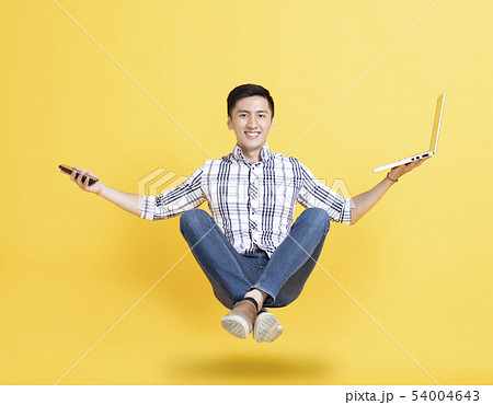 young man holding phone and floating in the air young man holding phone and floating in the air 54004643