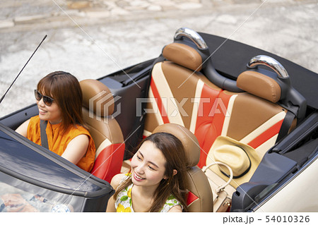 内装がおしゃれなオープンカーで観光スポットのカフェ巡りを楽しむ若い女性二人のライフスタイル 54010326