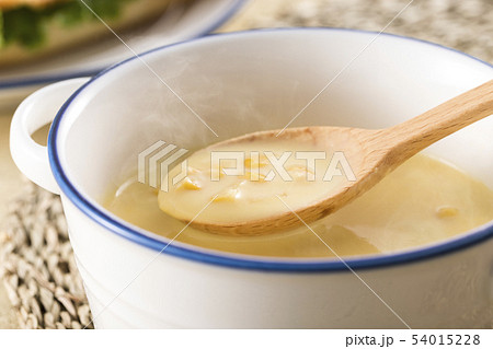 ほんのり湯気の立つ、スプーンですくったコーンクリームスープ 54015228