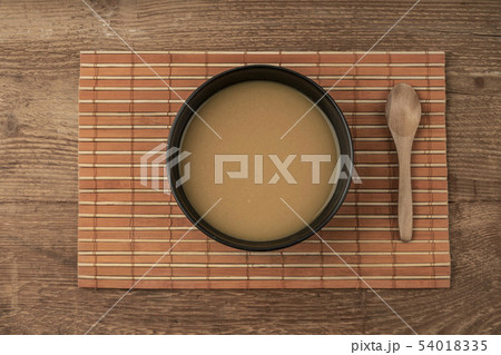 a bowl of soup on a wooden table a bowl of soup on a wooden table 54018335