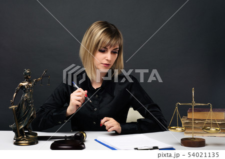A young fair woman judge works in her office. 54021135