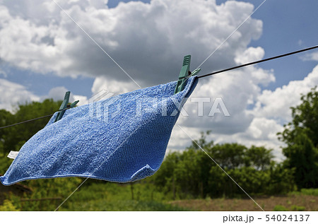Clothes peg on a blue towel and washing line Clothes peg on a blue towel and washing line 54024137