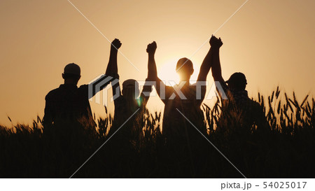 A group of successful young people hold hands, together they raise their upper hand. Successful team 54025017