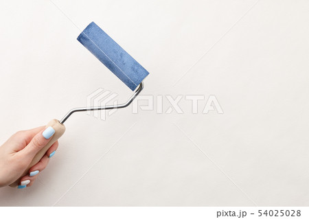 Female hand painting wall with roller Female hand painting wall with roller 54025028