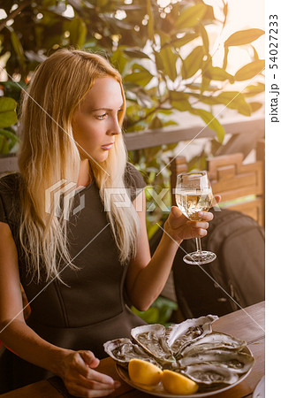 Beautiful girl close-up sits in a cafe at a table. Beautiful girl close-up sits in a cafe at a table. 54027233