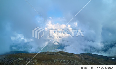 Mountain ridge with rocky outcrops. Panoramic view from the top of the ridge on background of valley Mountain ridge with rocky outcrops. Panoramic view from the top of the ridge on background of valley 54028962