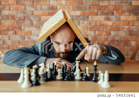 Male chess player with board on his head 54031641