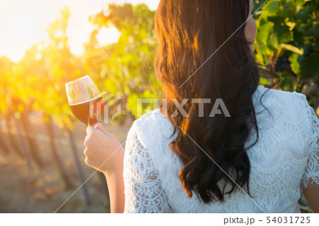 Young Adult Woman Enjoying Glass of Wine Tasting 54031725